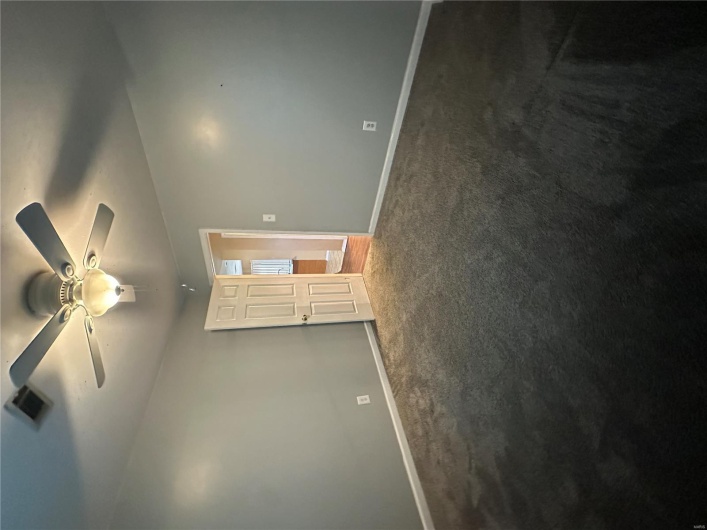 Carpeted spare room with visible vents, a ceiling fan, and baseboards