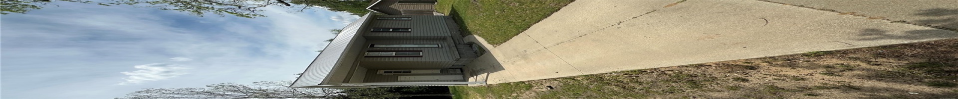 Residential For Sale View of front of home with metal roof, a front lawn, concrete driveway, and an attached carport