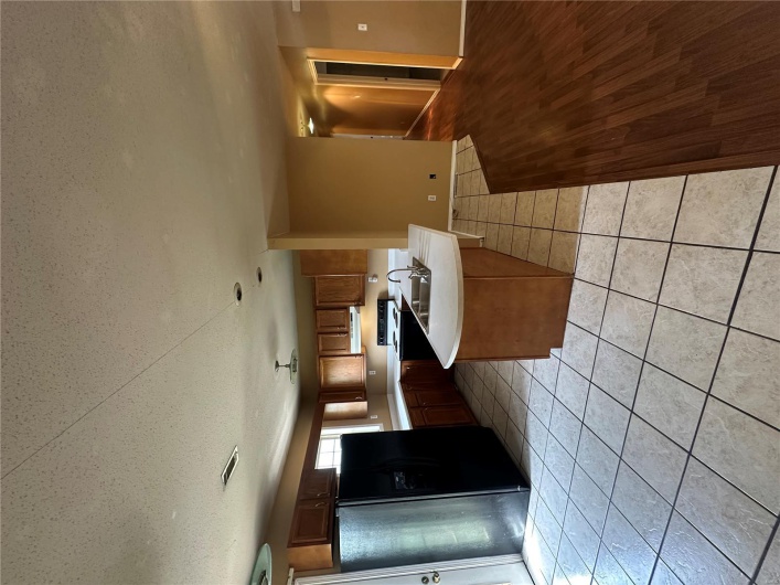 Kitchen featuring fridge, light countertops, range, exhaust hood, and visible vents