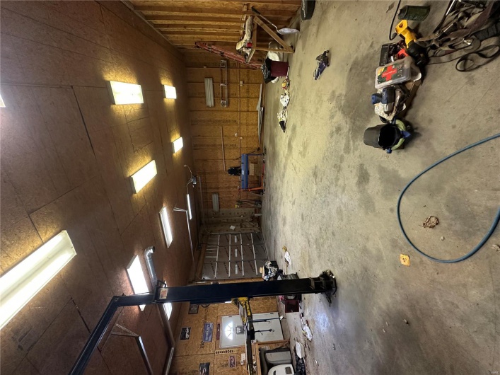 Misc room featuring unfinished concrete flooring and a garage