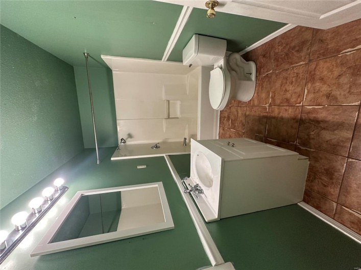 Bathroom with a textured ceiling, toilet, baseboards, vanity, and shower / tub combination