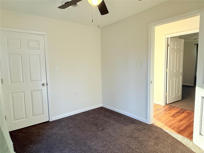 Spare room with a ceiling fan, baseboards, and carpet