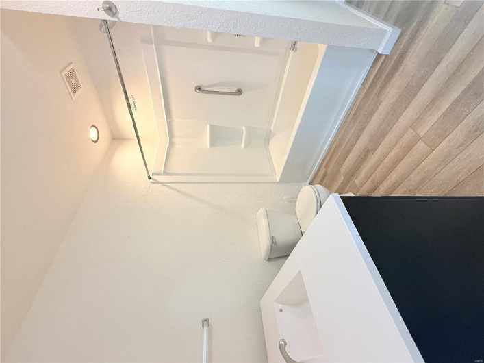 Bathroom featuring wood finished floors, vanity, washtub / shower combination, toilet, and visible vents