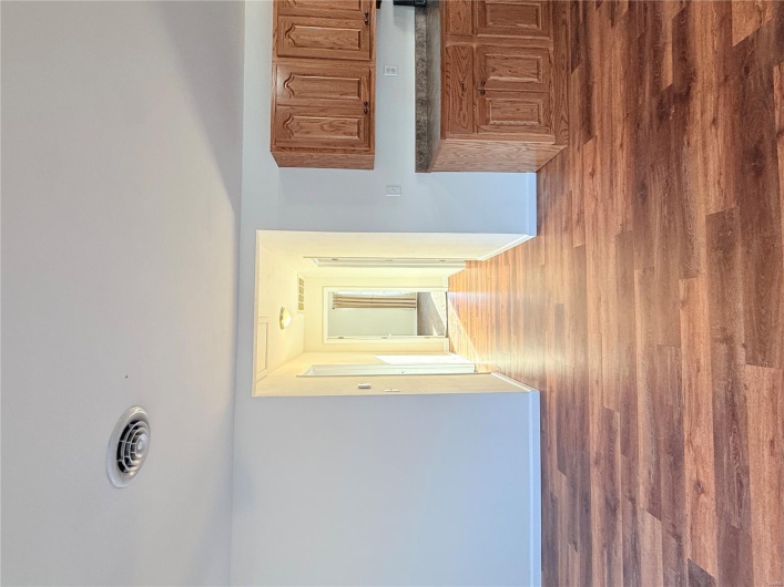 Kitchen featuring dark countertops, wood finished floors, visible vents, and baseboards