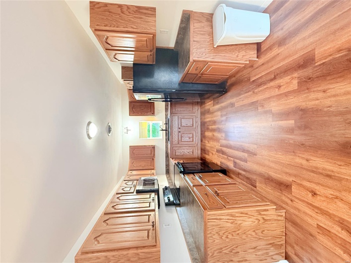 Kitchen with dark countertops, a sink, fridge, range, and light wood finished floors
