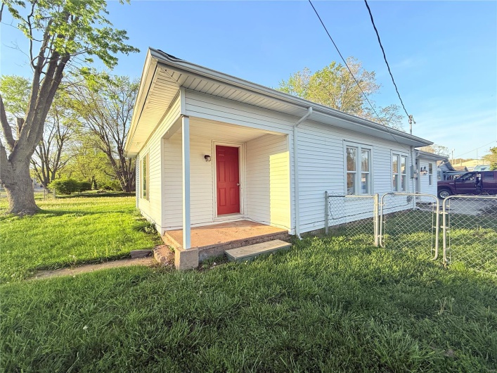 View of front of property with a front yard and fence