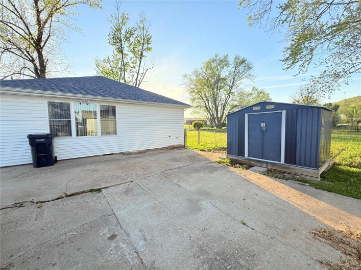 View of patio featuring an outdoor structure, fence, and a storage shed