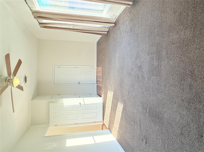 Carpeted spare room with visible vents, baseboards, and ceiling fan