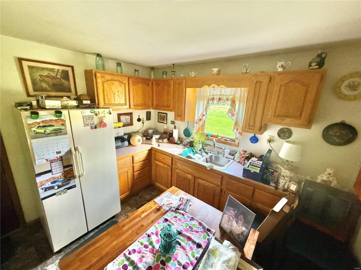 Kitchen with light countertops, freestanding refrigerator, and a sink