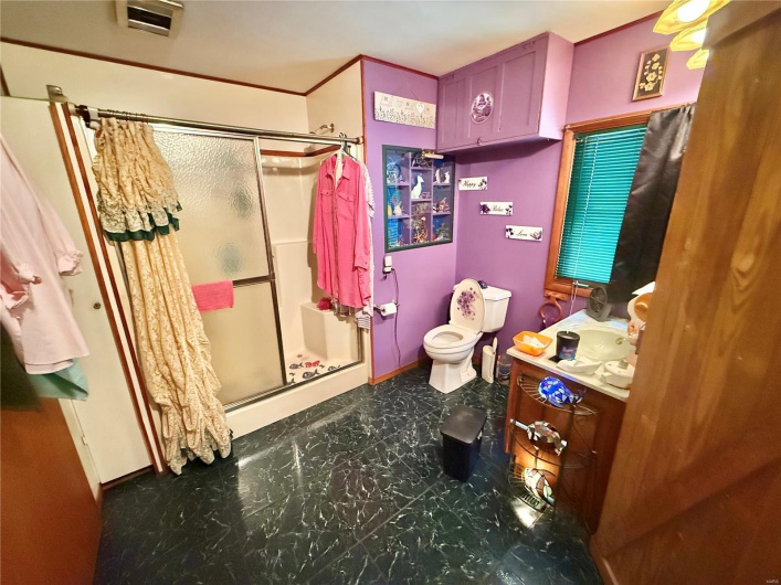 Bathroom with tile patterned floors, toilet, vanity, baseboards, and a stall shower