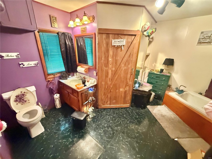 Full bathroom with a garden tub, vanity, and toilet