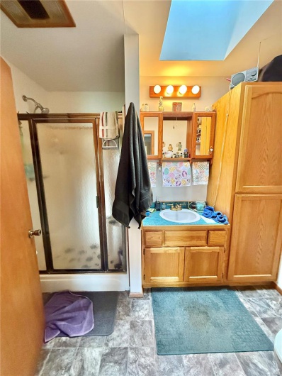 Bathroom featuring a shower stall and vanity