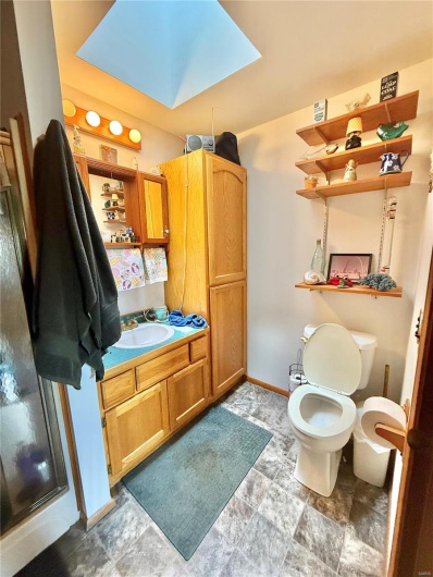 Bathroom with toilet, vanity, and baseboards
