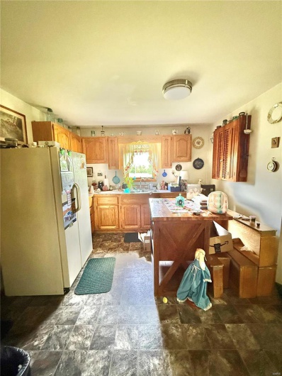 Kitchen featuring a sink, white refrigerator with ice dispenser, and light countertops
