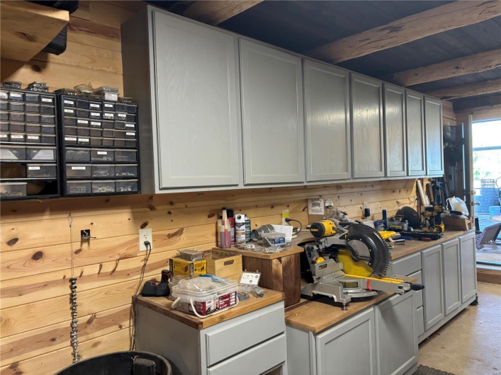 Kitchen featuring wooden walls, light countertops, and beam ceiling
