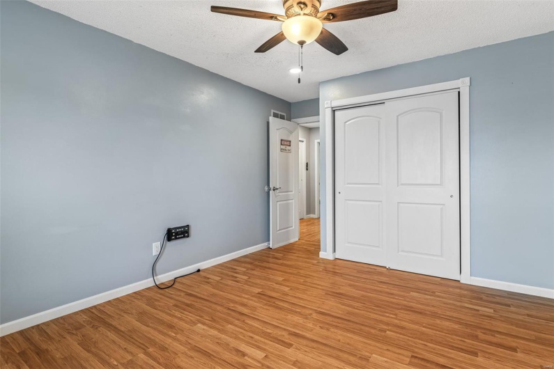 Unfurnished bedroom with baseboards, a textured ceiling, and light wood finished floors