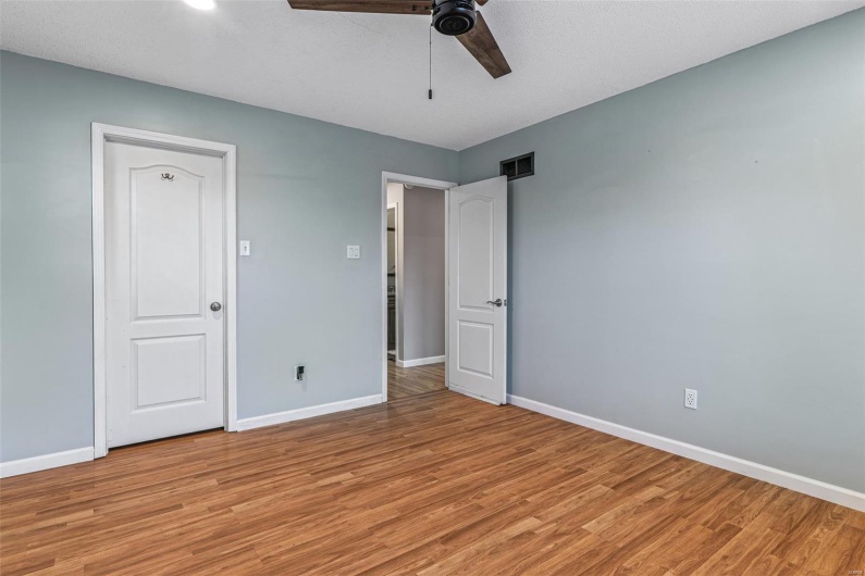 Unfurnished bedroom featuring ceiling fan, baseboards, light wood-style floors, and visible vents