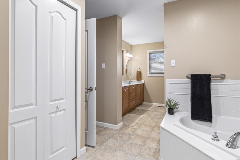 Bathroom with baseboards, vanity, and a garden tub