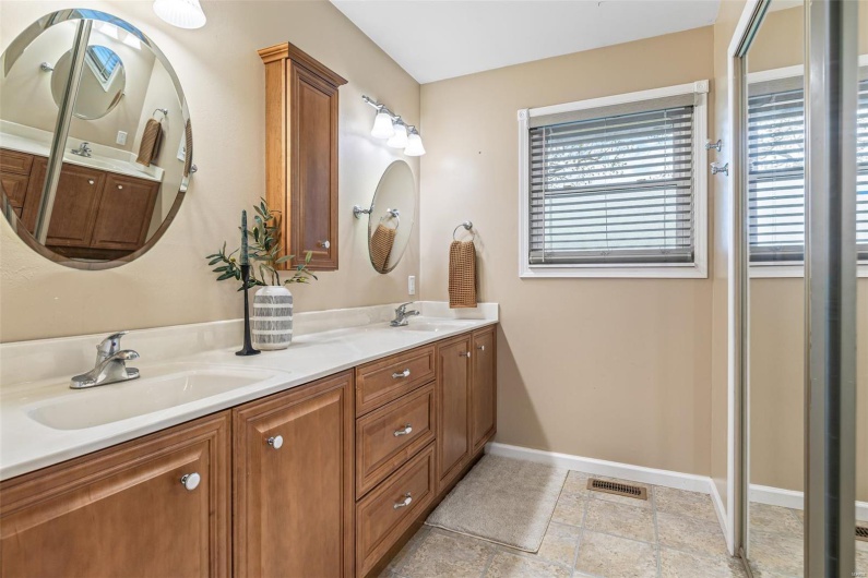 Bathroom featuring baseboards, a healthy amount of sunlight, and a sink