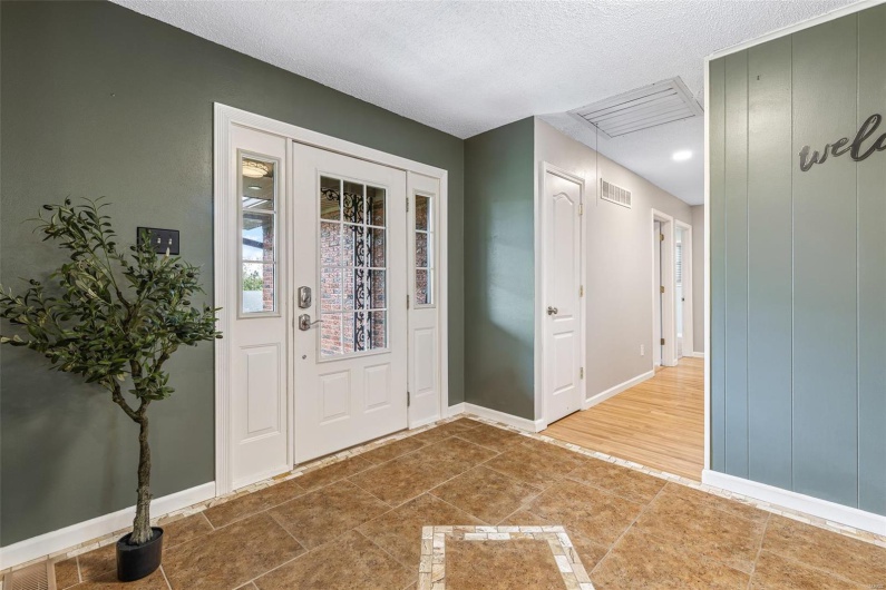 Entryway featuring baseboards, a textured ceiling, and visible vents