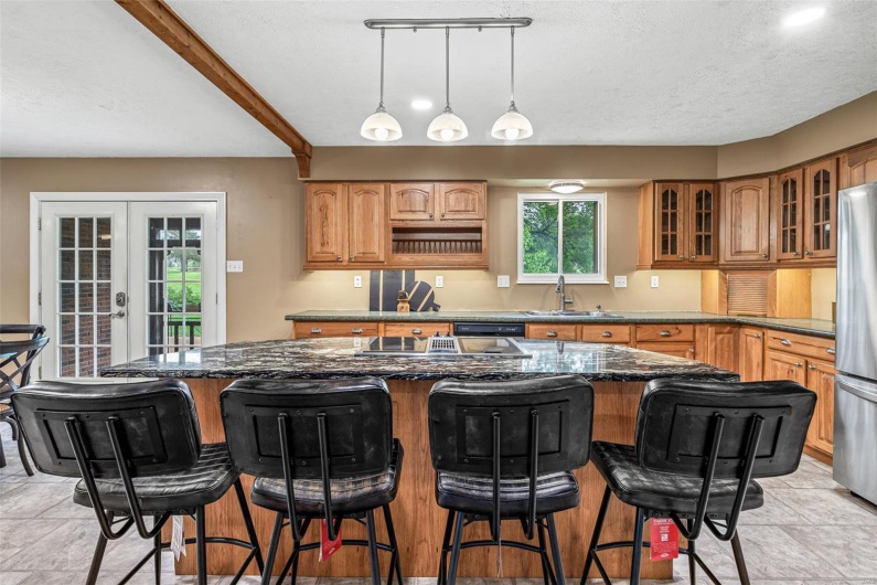 Kitchen featuring a sink, glass insert cabinets, french doors, a kitchen island, and freestanding refrigerator