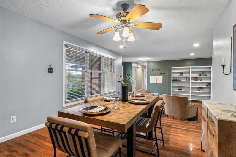Dining room with baseboards, a ceiling fan, wood finished floors, and a textured ceiling