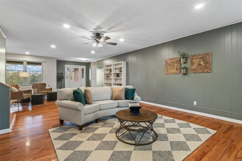Living area with baseboards, a ceiling fan, wood finished floors, and recessed lighting