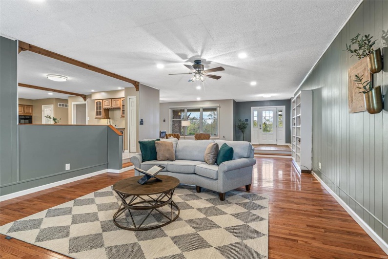 Living room with a textured ceiling, baseboards, recessed lighting, wood finished floors, and ceiling fan
