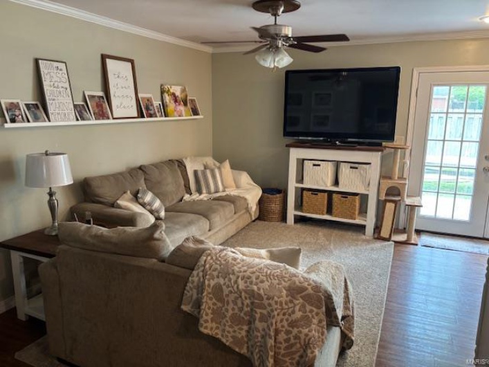 Living area featuring wood finished floors, crown molding, and a ceiling fan