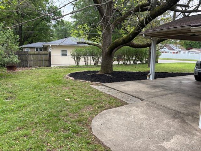 View of yard featuring fence and a patio