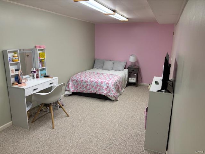 Bedroom featuring light carpet and baseboards