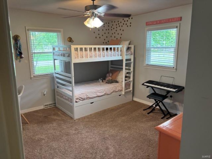 Bedroom with carpet flooring, baseboards, and a ceiling fan
