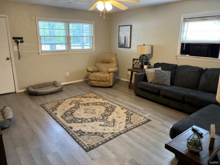 Living room featuring light hardwood / wood-style floors, cooling unit, and ceiling fan