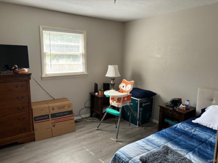Bedroom with wood-type flooring and a textured ceiling