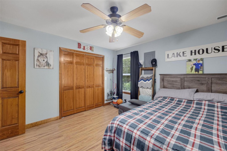 Bedroom with light wood-style flooring, a closet, baseboards, and ceiling fan