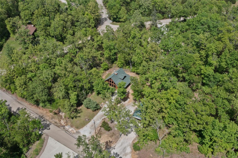 Aerial view of property's location featuring a forest