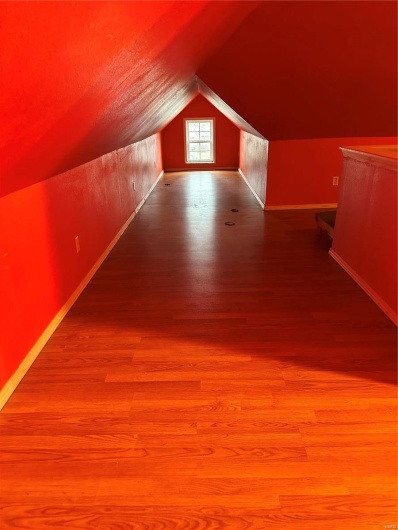 Additional living space featuring lofted ceiling and wood-type flooring