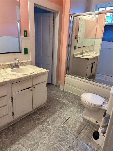 Full bathroom featuring vanity, shower / bath combination with glass door, and toilet