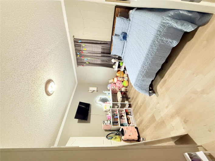 Bedroom with ornamental molding, a textured ceiling, and wood finished floors