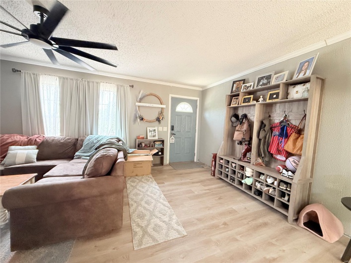 Mudroom featuring ornamental molding, a ceiling fan, a textured ceiling, and light wood finished floors