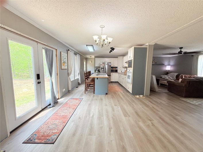 Kitchen with open floor plan, stainless steel appliances, plenty of natural light, and a textured ceiling