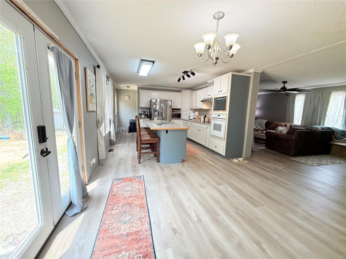 Kitchen featuring open floor plan, a breakfast bar, stainless steel appliances, and a textured ceiling