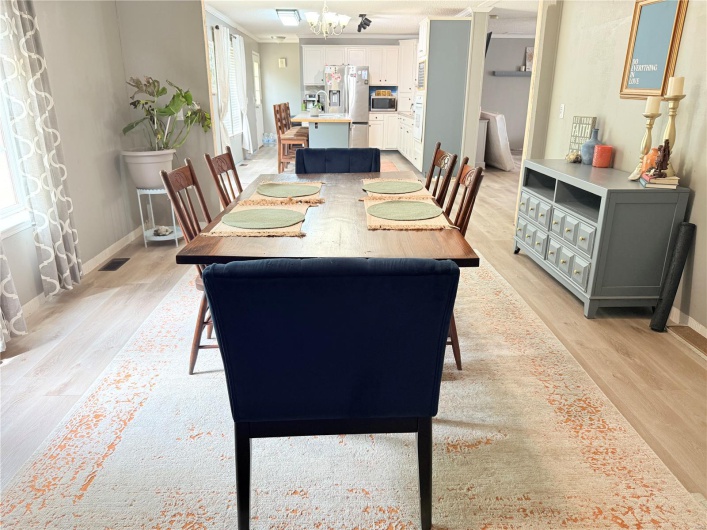 Dining space featuring light wood finished floors, visible vents, a chandelier, and baseboards