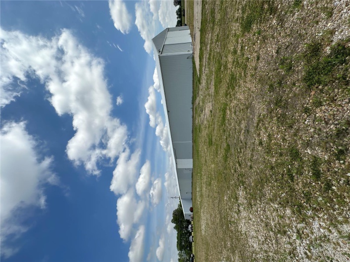 View of yard with a pole building and an outbuilding