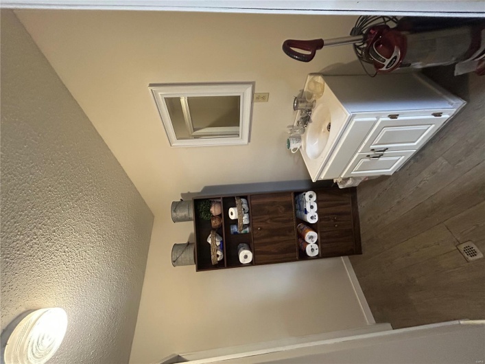Bathroom featuring a textured ceiling, wood finished floors, and vanity