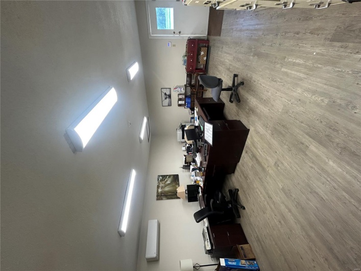Office area featuring wood finished floors and an AC wall unit