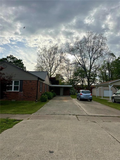View of front facade featuring brick siding, a front lawn, and concrete driveway