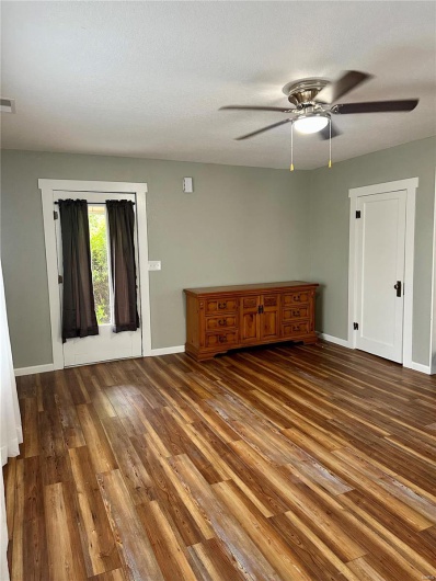 Spare room with a ceiling fan, visible vents, wood finished floors, and baseboards