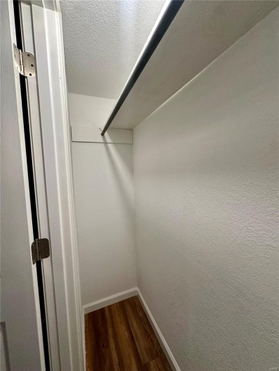 Walk in closet with wood finished floors