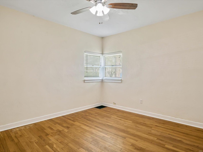 Empty room featuring ceiling fan, baseboards, and light wood-style floors